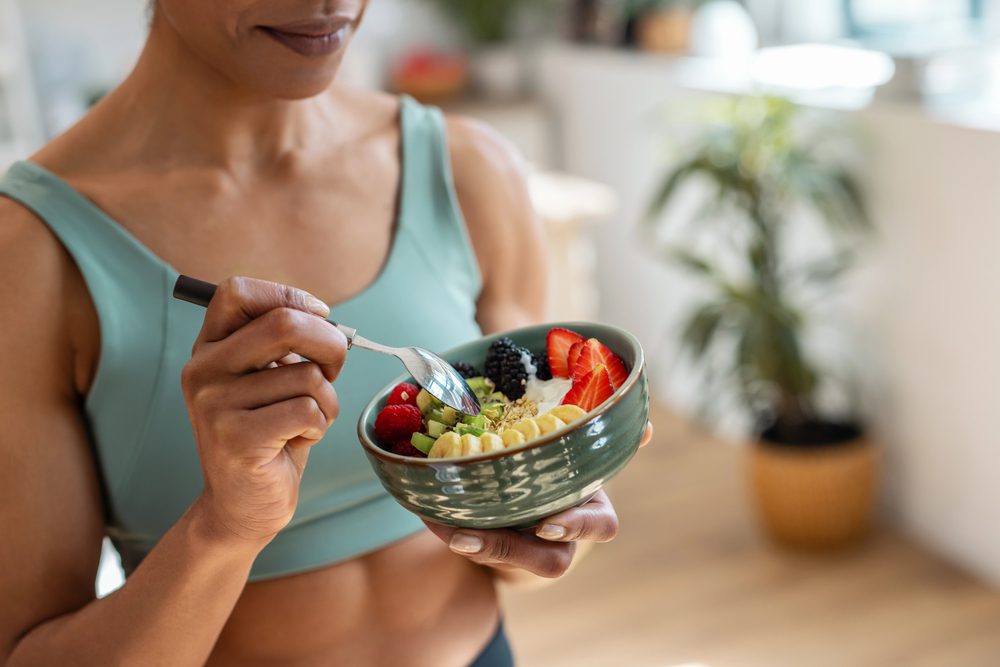 Jeune femme mangeant des fruits pour faire le plein d'énergie