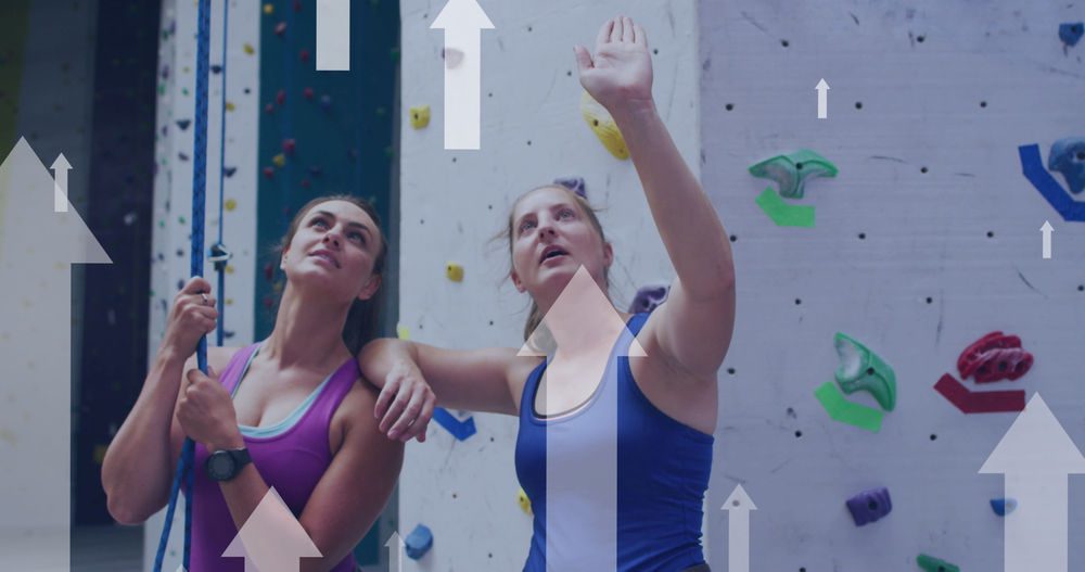 Jeunes femmes échangeant sur la meilleure manière de monter une voie dans une salle d'escalade